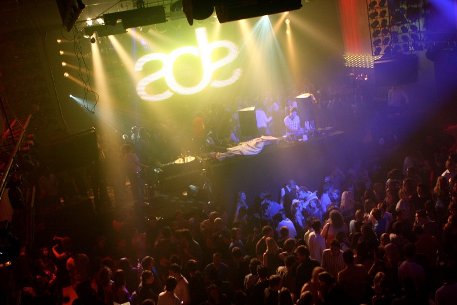 A packed ADE night with the ade logo lit above the stage